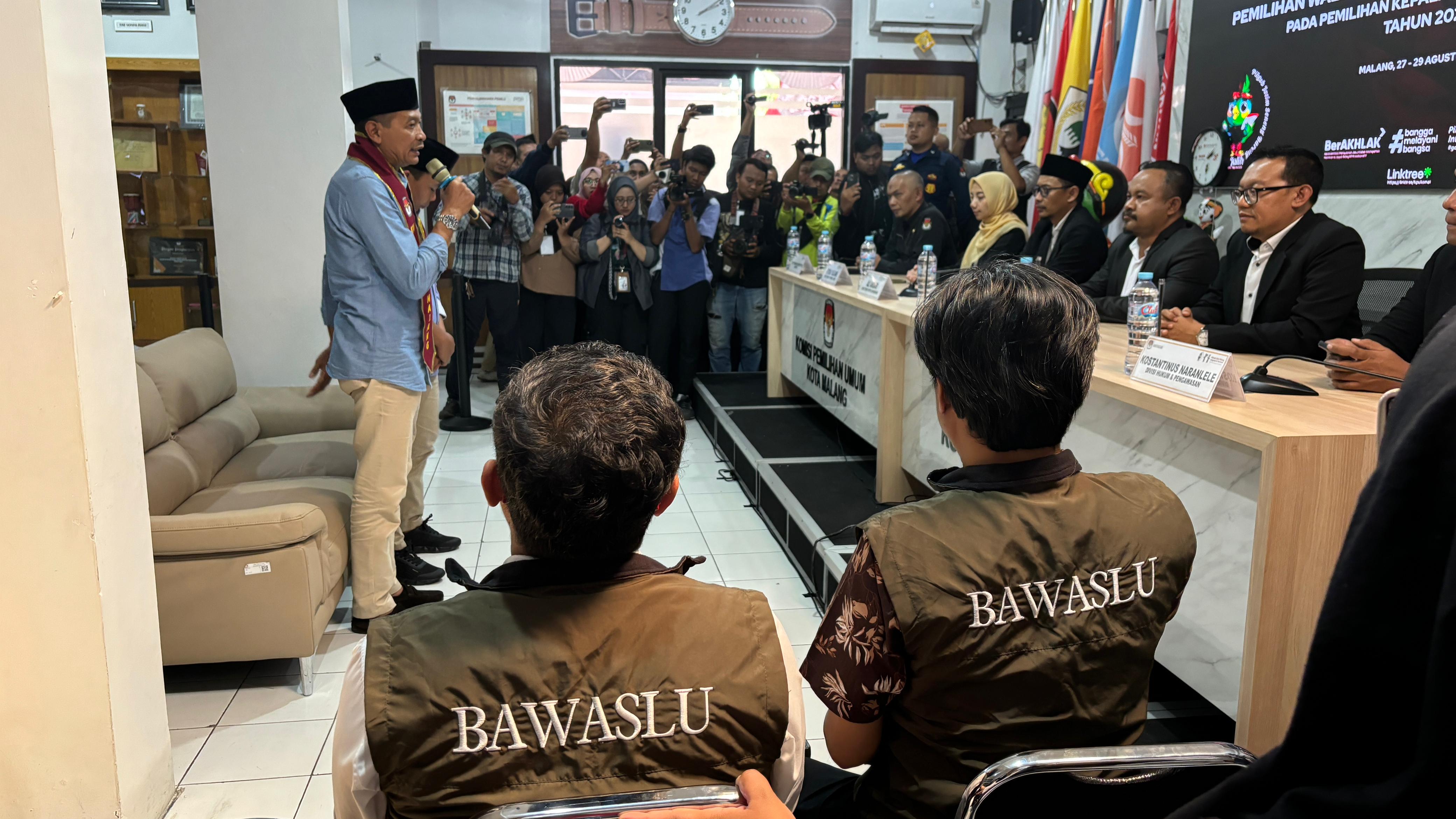 M. Hasbi (kiri) dan Iwan Sunaryo (kanan) selaku Anggota Bawaslu Kota Malang terlihat sedang mengawasi secara melekat prosesi penyerahan berkas pendaftaran Bapaslon Walikota dan Wakil Walikota Malang di KPU Kota Malang hari ini (28/08).