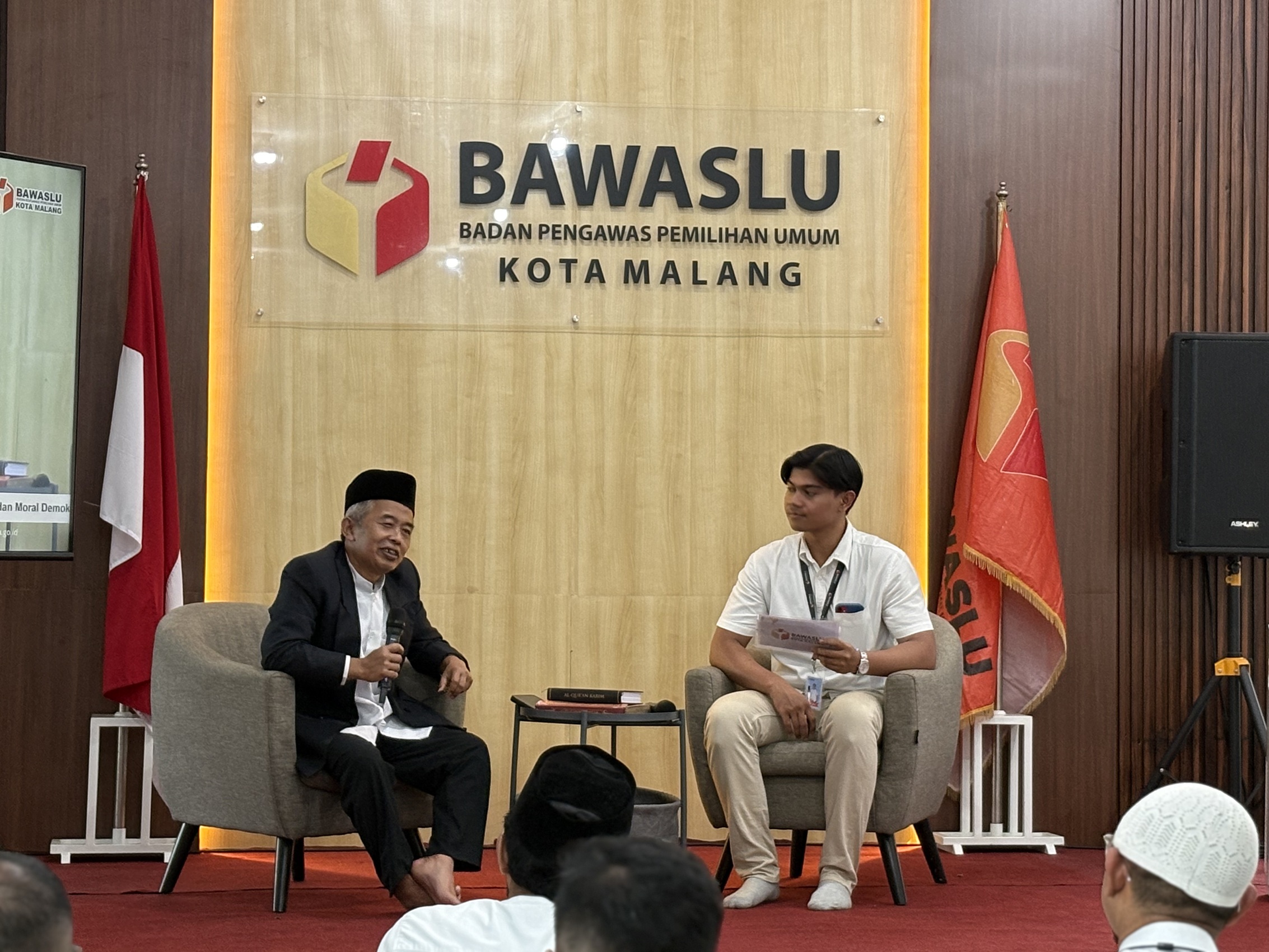 DIALOG Ustadz Insan Muhtadwan berdialog bersama moderator dalam kegiatan Ngabuburit Pengawasan Bawaslu Kota Malang, membahas pentingnya nilai moral dan akhlak dalam menjaga kualitas demokrasi.