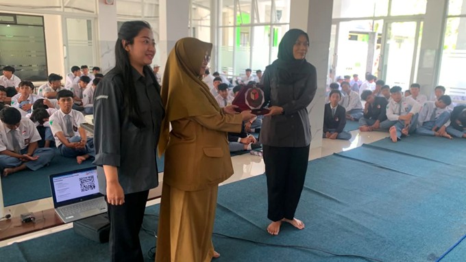 APRESIASI Perwakilan SMKN 9 Kota Malang menyerahkan cendera mata dalam kegiatan Konsolidasi Demokrasi bersama Bawaslu Kota Malang bertajuk “Efektivitas Pengawasan Pemilu dalam Menekan Pelanggaran Politik”, Senin (8/6/2026).