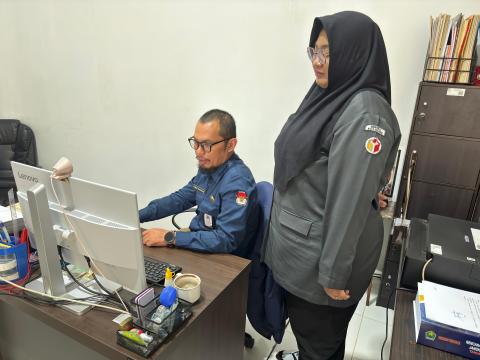 PANTAU PROGRESS: Rista (Kanan), Staf Teknis Bawaslu Kota Malang sedang memantau perkembangan ungahan data syarat dukungan paslon di Kantor KPU Kota Malang hari ini (30/07).